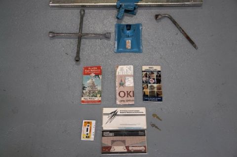 1978 Ford E250 - Collection of automotive tools and paperwork, including a jack, wrenches, and service manuals.