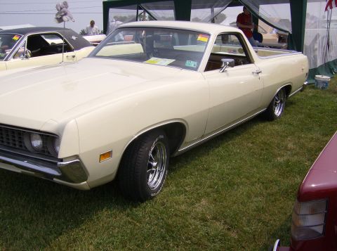 1970 Ford Ranchero - A cream-colored 1970 Ford Ranchero is parked on a grassy field, with another vehicle visible to its left.