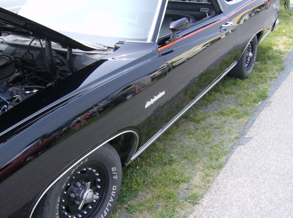 Black 1970 Ford Ranchero with hood open, showing engine detail
