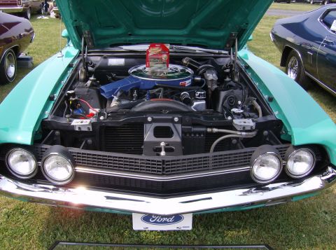 1970 Ford Ranchero - A teal 1970 Ford Ranchero is displayed with its hood open, revealing the engine bay and front end.