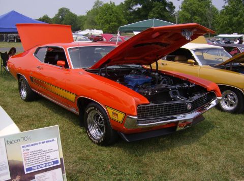 1970 Ford Ranchero - An orange 1970 Ford Falcon Ranchero is displayed with its hood open, parked next to a yellow car.