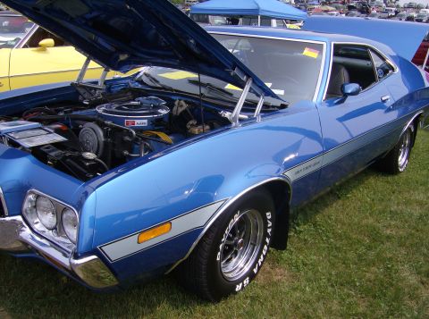 1970 Ford Ranchero - A blue coupe is parked on grass with its hood and trunk open, revealing the engine bay.