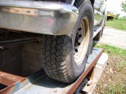 1978 Ford E250 - Close-up view of a vehicle's chrome bumper and tire, with the vehicle positioned on a ramp.