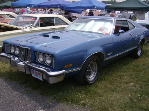 1970 Ford Ranchero - This blue coupe features a distinctive grille and dual hood scoops, with a license plate from 1973.