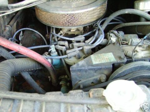 1978 Ford E250 - Close-up view of the engine compartment in a 1978 Ford E250, showing the carburetor, air filter, and various hoses.