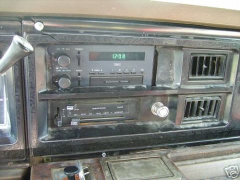 1978 Ford E250 - The interior of a 1978 Ford E250 features a digital clock radio and manual climate controls.