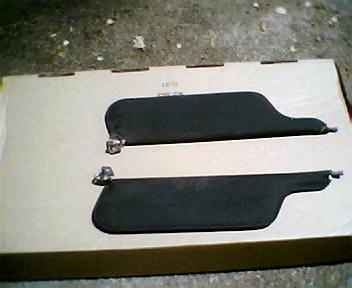 1973 Ford Ranchero - A pair of sun visors are presented on a cardboard surface, ready for installation or storage.