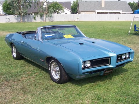 2002 Ford Mustang - Classic blue 1969 Pontiac GTO convertible with hood scoops and chrome wheels.