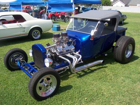 2002 Ford Mustang - A custom blue hot rod pickup truck is displayed outdoors with other vehicles.