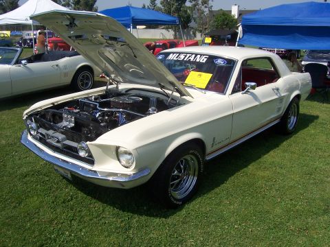 2002 Ford Mustang - A white 1967 Ford Mustang coupe is displayed with its hood open, revealing the engine bay.