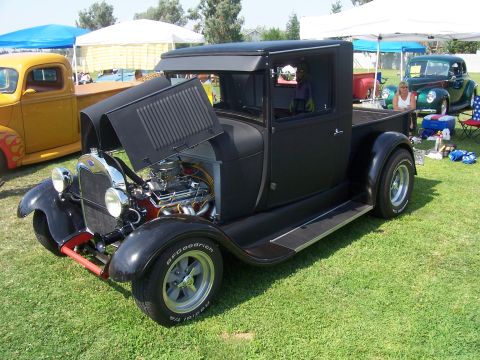 2002 Ford Mustang - Hot rod pickup truck on display at an outdoor car show with other vehicles present.