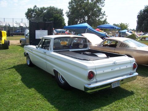 2002 Ford Mustang - A white pickup truck is parked on a grassy field next to other vehicles and tents.