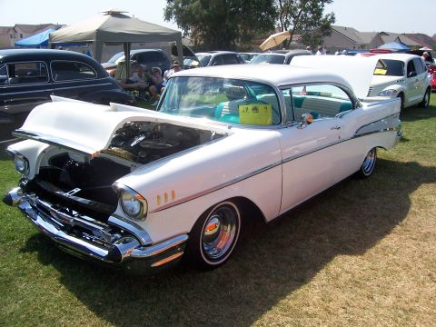 2002 Ford Mustang - A classic 1957 Chevrolet Bel Air is displayed with its hood open, showing the engine compartment.