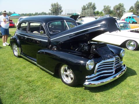 2002 Ford Mustang - A black sedan with its hood open sits on a grassy field next to other vehicles.