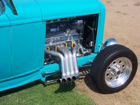 2002 Ford Mustang - Close-up of a custom hot rod's engine compartment, polished components and bright yellow spark plug wires.