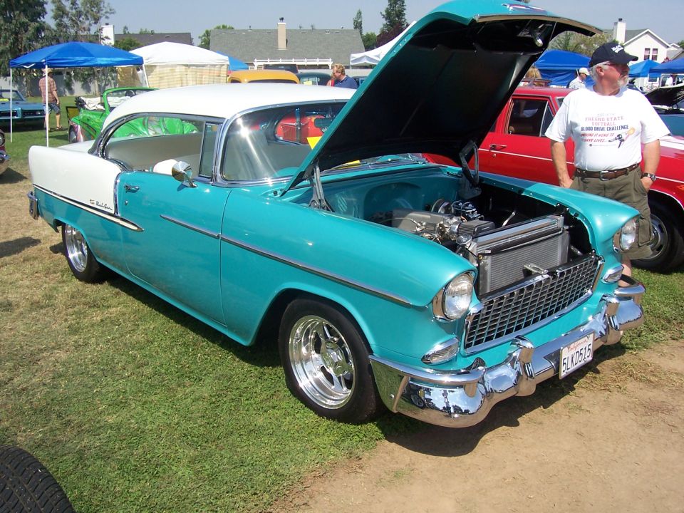 Turquoise and white 1955 Chevrolet Bel Air coupe, hood open, chrome wheels