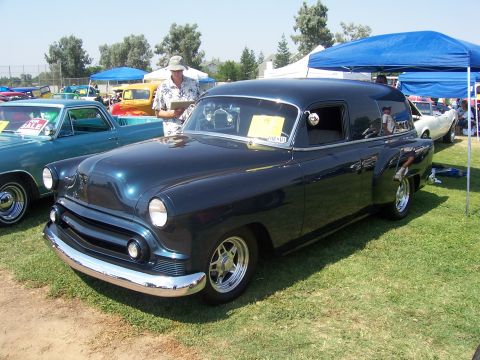 2002 Ford Mustang - A dark blue panel van is displayed outdoors with other vehicles and tents.