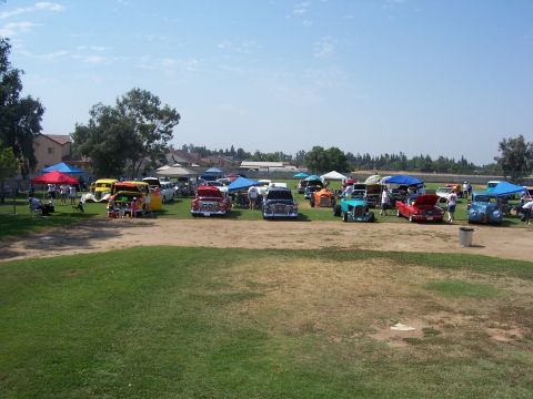 2002 Ford Mustang - A gathering of classic cars displayed at an outdoor event under a clear blue sky.