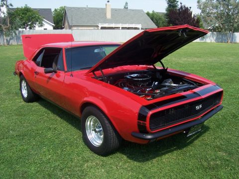 2002 Ford Mustang - A red 1967 Chevrolet Camaro SS is shown with both hoods open, revealing the engine compartment.