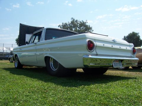 2002 Ford Mustang - A white 1960 Ford Falcon Ranchero is parked on grass with its hood up, showing its rear end and chrome bumper.