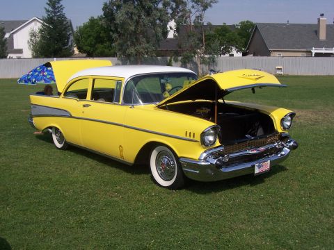 2002 Ford Mustang - This classic 1957 Chevrolet Bel Air sedan is displayed with both hoods open on a grassy field.