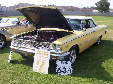 2002 Ford Mustang - 1963 Ford Galaxie 500 XL on display with hood open, showing the engine bay.
