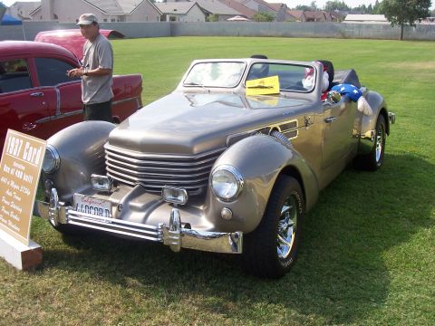 2002 Ford Mustang - A classic 1937 Cord convertible is displayed on a grassy field next to a descriptive sign.