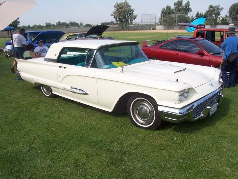 2002 Ford Mustang - A white classic car, possibly a 1958 Ford Thunderbird, is displayed outdoors with other vehicles.