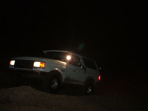 1989 Ford Bronco - This 1989 Ford Bronco is captured in a three-quarter front view during nighttime off-roading.