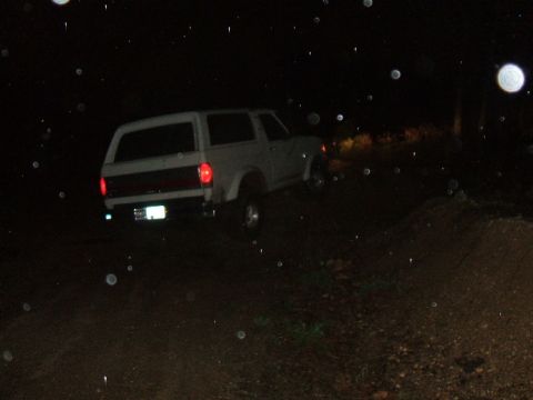 1989 Ford Bronco - White 1989 Ford Bronco driving off-road at night.