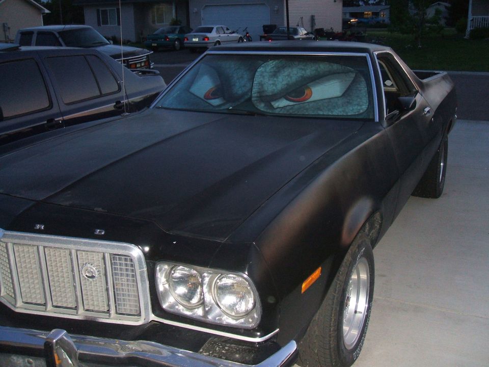 Black 1974 Ford Ranchero with cartoon eye sunshade on windshield