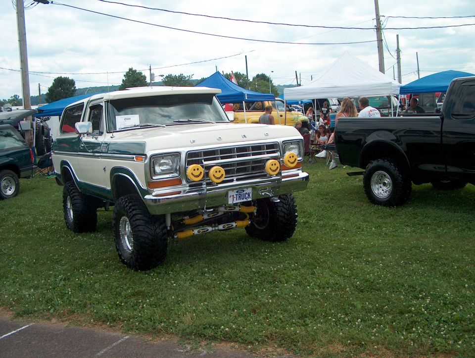 Lifted cream and green Ford Bronco with smiley face lights on the front