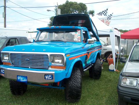 1978 Ford Bronco - A bright blue 1978 Ford Bronco is displayed with its hood open and top raised at an outdoor event.