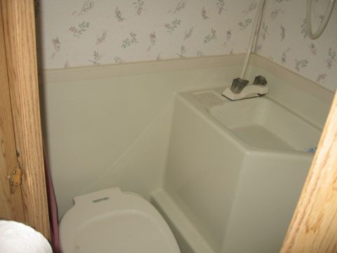 1996 Dodge 2500 - Bathroom interior with toilet and bathtub, wallpaper on the wall.