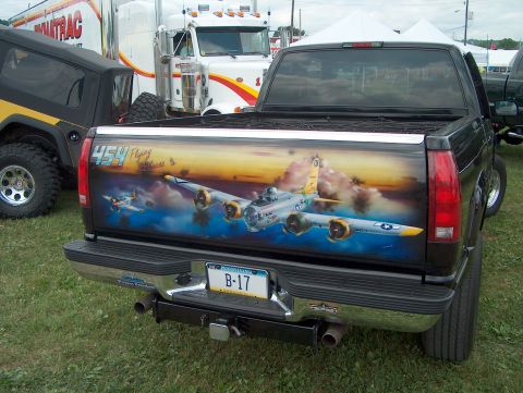 1978 Ford Bronco - The tailgate of a black pickup truck features a custom mural of B-17 Flying Fortresses in flight.