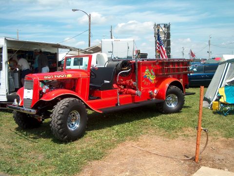 1978 Ford Bronco - This custom fire truck, labeled "Hot Foot", is parked on grass with tents and other vehicles in the background.