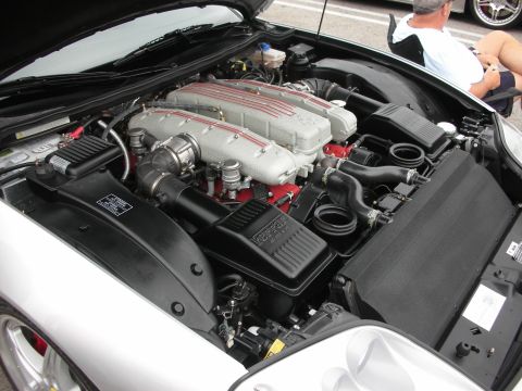 1998 Ford Crown Victoria - A close-up view of a powerful Ferrari V12 engine, its intricate mechanical components and red detailing.