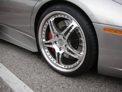 1998 Ford Crown Victoria - A close-up view of a customized wheel and fender on a silver vehicle, highlighting aftermarket modifications.