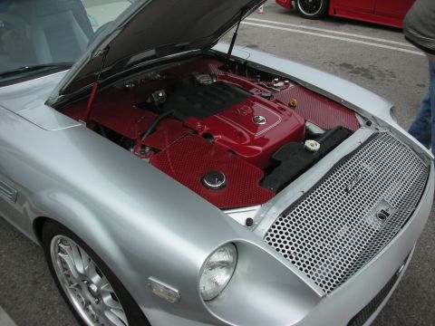 1998 Ford Crown Victoria - Customized engine bay of a silver sports car, a red engine cover and aftermarket grille.