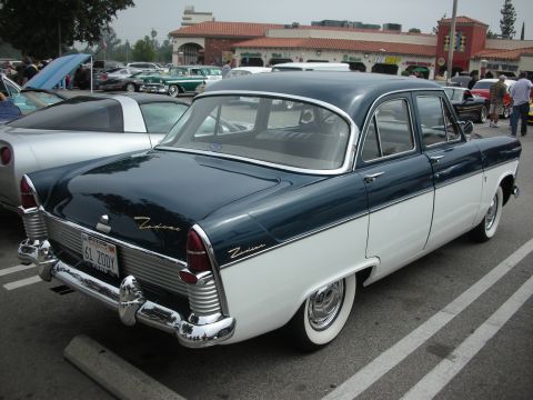 1998 Ford Crown Victoria - A two-tone blue and white 1961 Ford Zodiac sedan is parked at a car meet, with other vehicles visible in the background.
