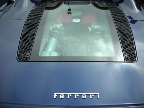 1998 Ford Crown Victoria - The rear of a blue Ferrari shows its engine through a glass panel, with the Ferrari script emblem below.