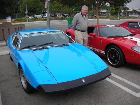 1998 Ford Crown Victoria - A bright blue De Tomaso Pantera is parked next to a red Ford GT at a car meet.