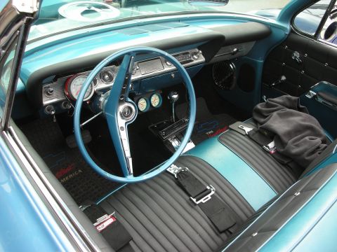 1998 Ford Crown Victoria - The interior of a classic Chevrolet Impala features a turquoise and black color scheme with racing-style seatbelts.