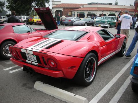 1998 Ford Crown Victoria - A red Ford GT sports car is parked at a car meet, with other vehicles visible in the background.