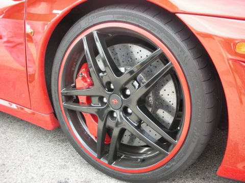 1998 Ford Crown Victoria - Close-up of a custom wheel on a red vehicle, a black five-spoke design with a red accent ring and red brake calipers.