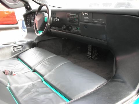 1998 Ford Crown Victoria - The interior of a car features gray leather seats with teal accents and a dashboard with an Infinity audio system.