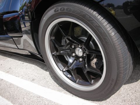 1998 Ford Crown Victoria - Close-up of a black aftermarket wheel and Goodyear tire on a car.
