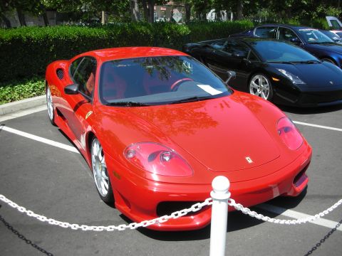 1998 Ford Crown Victoria - A bright red sports car is parked in front of a black sports car.