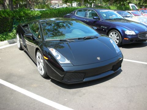 1998 Ford Crown Victoria - Black Lamborghini Gallardo parked in a lot with other vehicles.