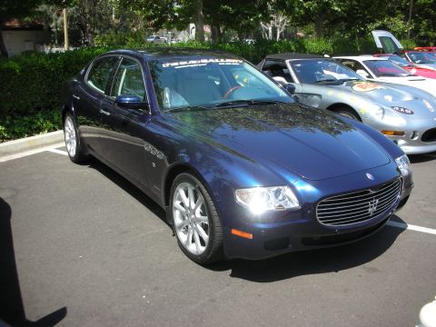 1998 Ford Crown Victoria - A dark blue sedan is parked in a lot with other vehicles visible in the background.